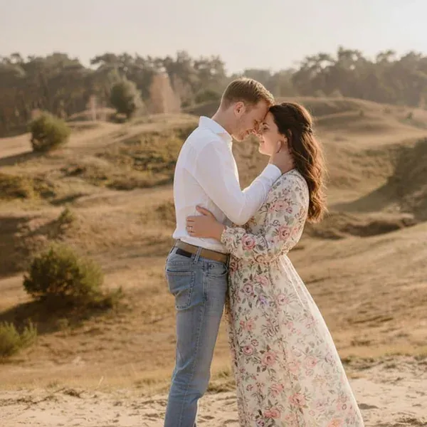 Een verloofd koppel samen in een zonnig landschap