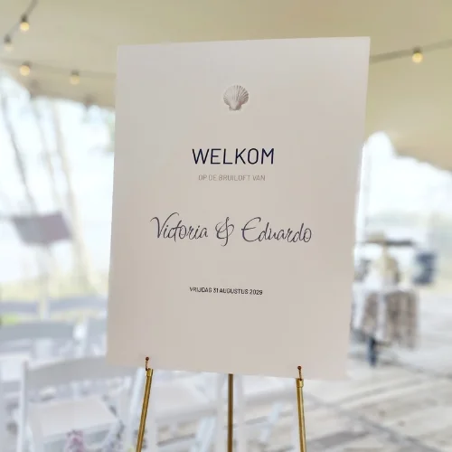 Welkomstbord voor bruiloft met schelp voor strandthema